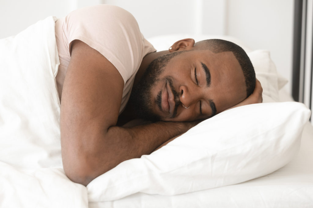Man sleeping on white pillow with white comforter