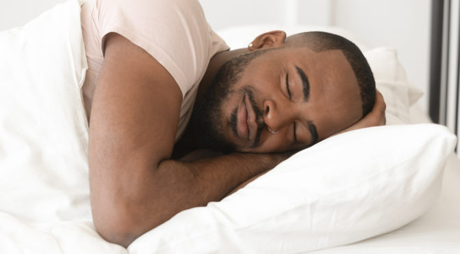 Man sleeping on white pillow with white comforter