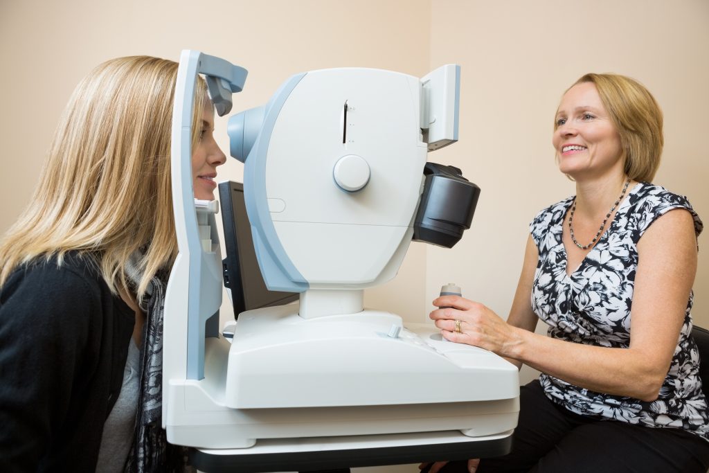 Woman getting a retinal scan with female eye doctor