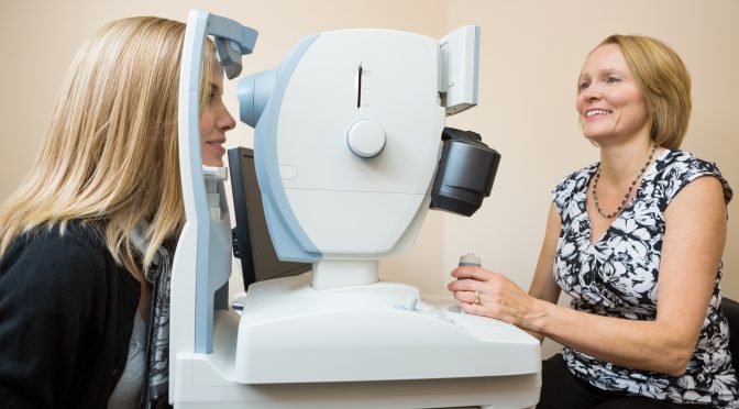 Woman getting a retinal scan with female eye doctor