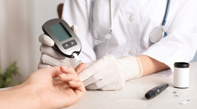 Health care provider giving a person a blood sugar (glucose) test.