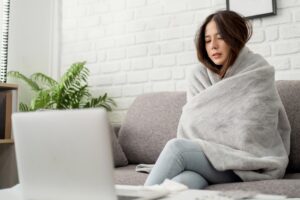 woman wearing a blanket on a couch